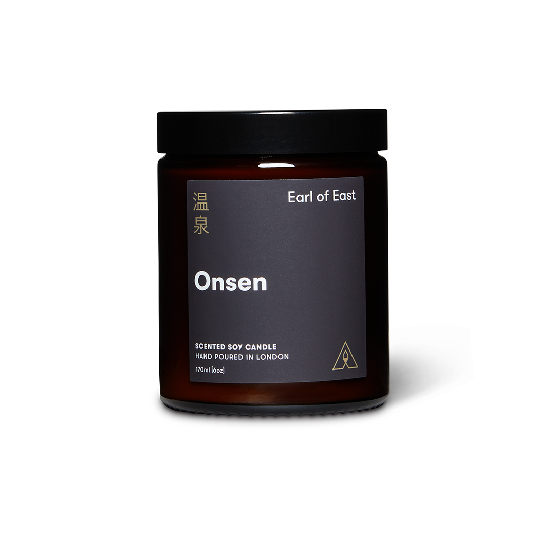 Dark brown candle jar with 'Earl of East' branding on a white background