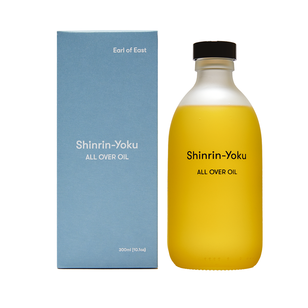 Yellow bottle and blue box of Shinrin-Yoku All Over Oil by Earl of East on a white background