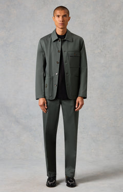 Man wearing a gray jacket and pants against a plain background