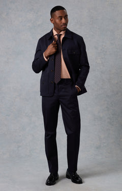 Man wearing a dark suit and tie against a gray background