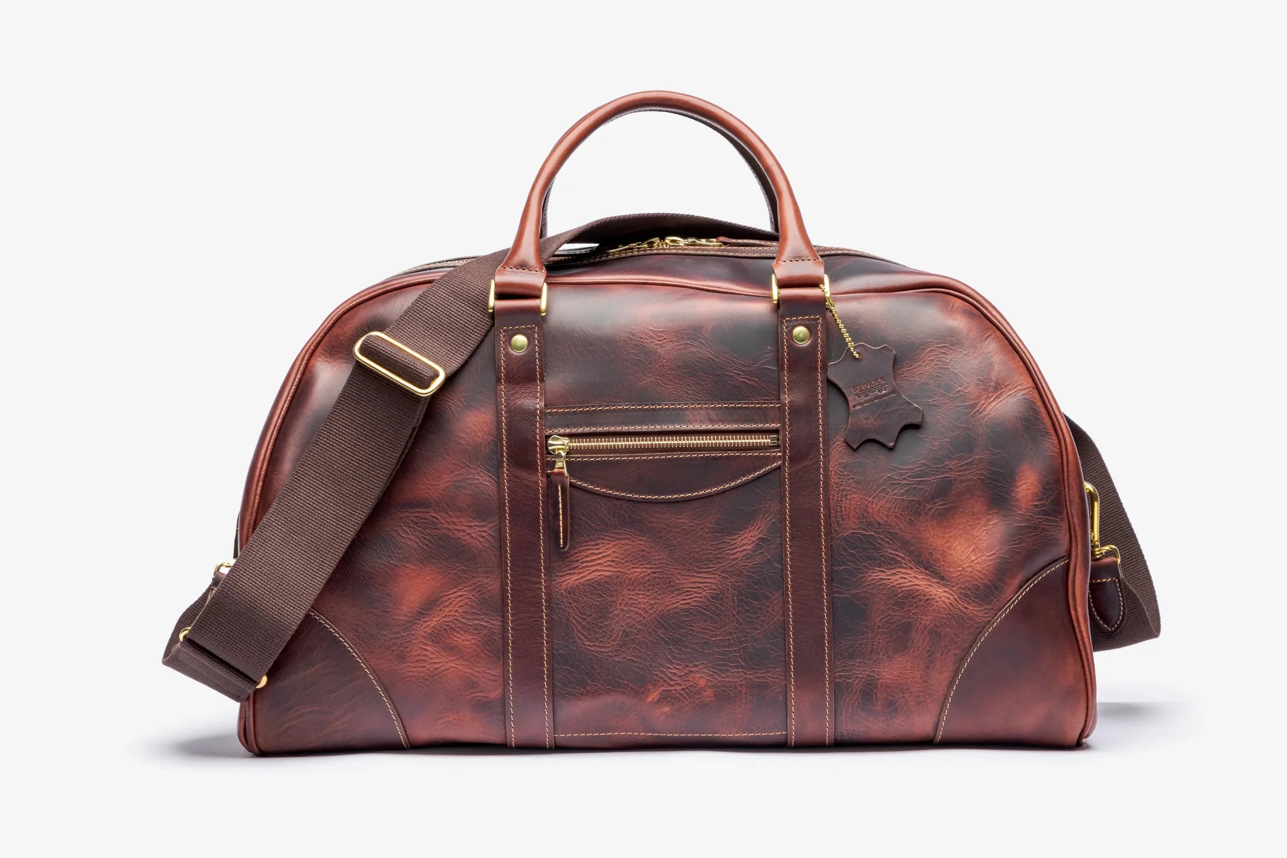 Brown leather duffel bag with gold accents on a white background