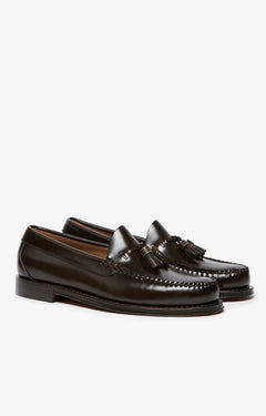 A pair of dark brown leather penny loafers with tassel straps, photographed on a clean white background.
