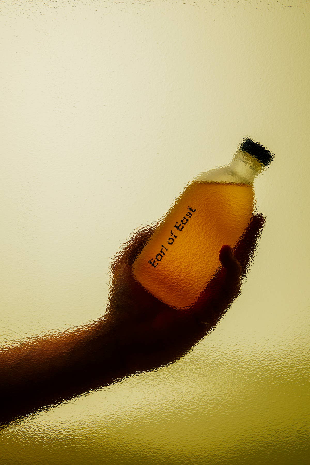 Hand holding a bottle labeled 'Lord of the Beasts' against a yellow background